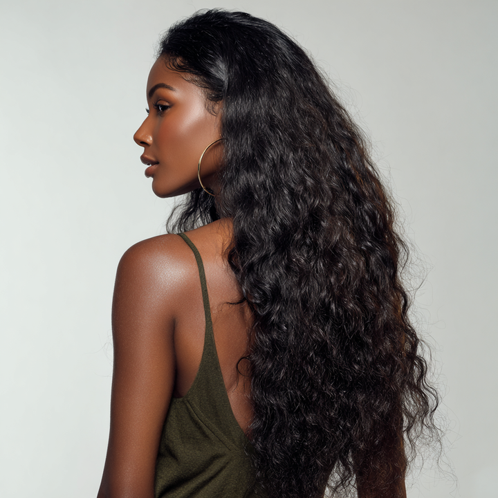 Woman with long, curly hair wearing a green top against a neutral background